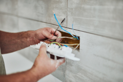 Electrician repairing / fixing wires in the wall.